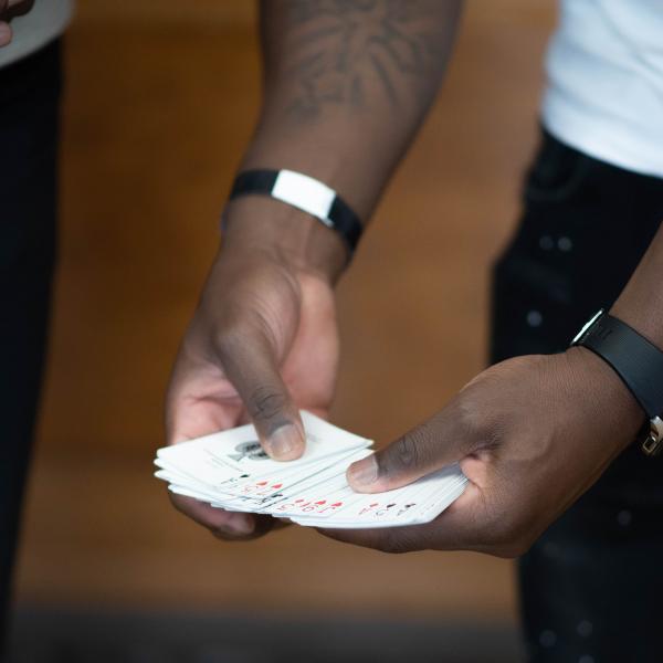 Close up image of magician showing a group of people a deck of playing cards