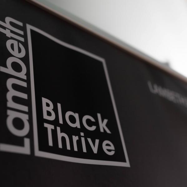 Photo of Lambeth Black Thrive branding material with black background and white text