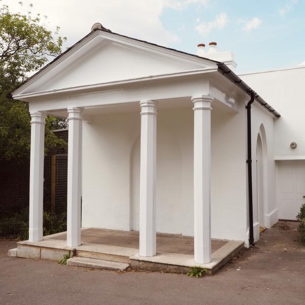 External facade of Brockwell Folly showing small venue with white pillars and blue skies in background