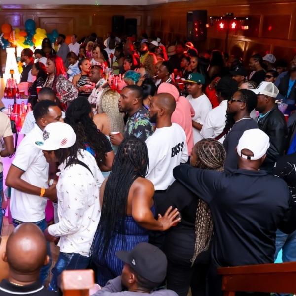 a group of people celebrating and dancing in a busy venue 