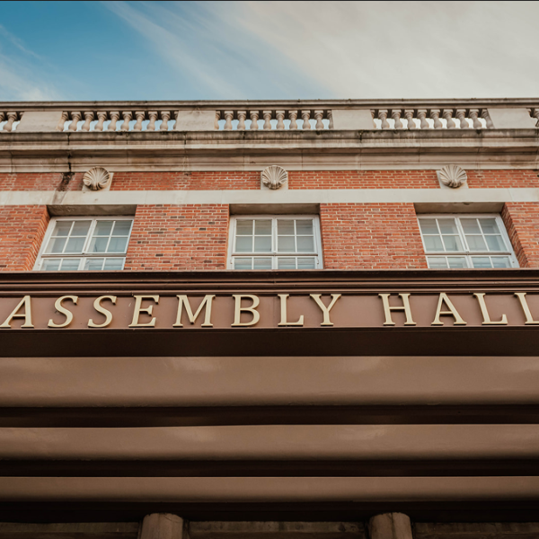 External venue image of gold art-deco text saying Assembly Hall